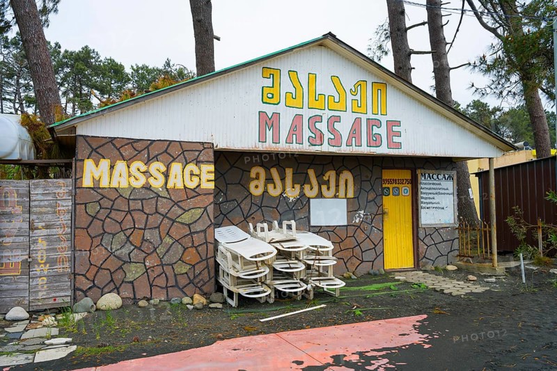 Colourful building with massage signs and stacked loungers outside, beach massage equipment with magnetic sand, magnetite, ureki, Guria region, Georgia