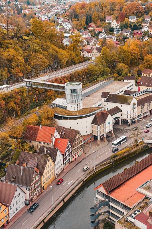 Aerial view of a city with colorful autumn leaves, river and central tower building, Hermann Hessebahn, ZOB Calw, Germany