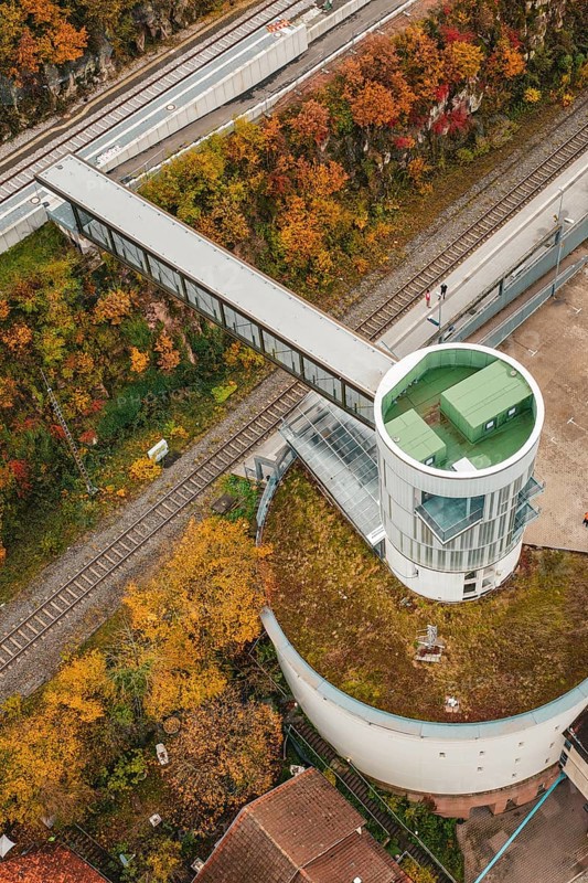 Aerial view of an observation tower with bridge over railroad tracks, surrounded by autumn leaves, Hermann Hessebahn, ZOB Calw, Germany