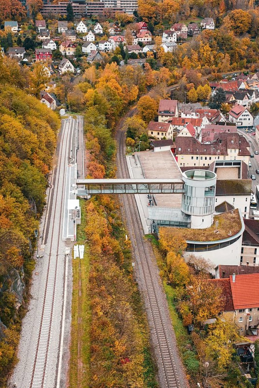 View of railroad, tower and municipal buildings surrounded by autumn colors, Hermann Hessebahn, ZOB Calw, Germany