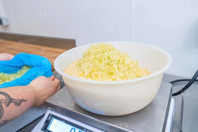 Person holding bags while bowl of sugar is on the scale in a kitchen, Christmas baking, Haselstaller Hof, Wildberg, Germany