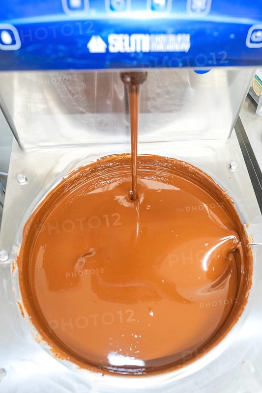 Close-up of liquid chocolate flowing from a machine, Christmas baking, Haselstaller Hof, Wildberg, Germany