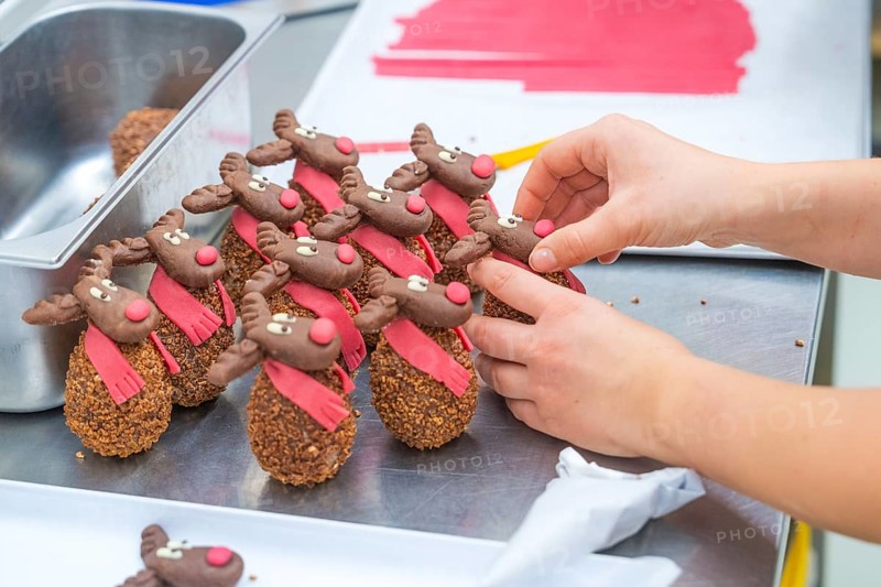 Chocolate reindeer with red scarves are decorated by hand, Christmas baking, Haselstaller Hof, Wildberg, Germany