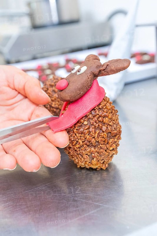 Hand sculpting a chocolate reindeer praline with red scarf and nose, Christmas baking, Haselstaller Hof, Wildberg, Germany