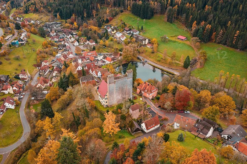 A castle and an idyllic village on a river surrounded by autumn trees, Berneck Castle, Altentsteig, Calw District, Germany
