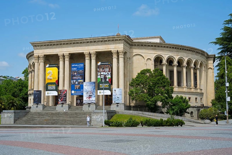A magnificent theatre building with posters on pillars and trees in the foreground, Lado Meskhishvili Dramatic Theatre, David Aghmashenebeli Central Square, Kutaisi, Imereti Region, Georgia