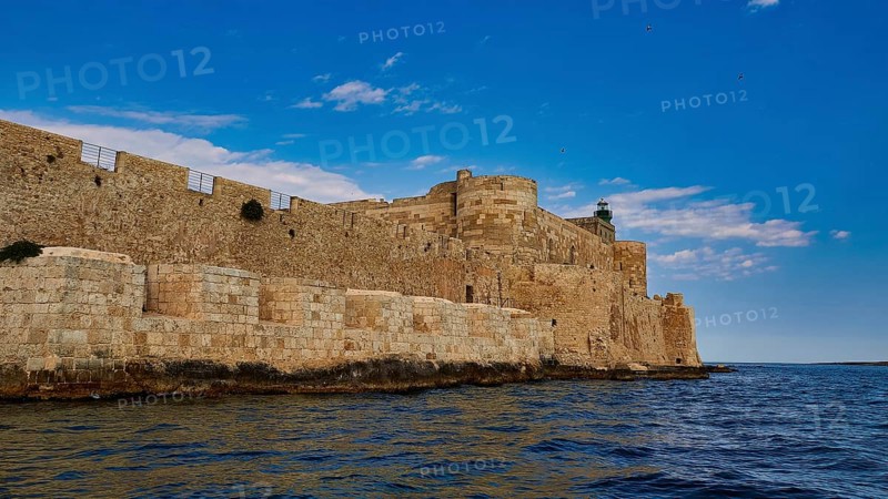 Syracuse, Ortigia island, sea fortress, extensive stone walls of an old fortress on the coast under blue sky, Baroque towns of Sicily, Baroque corner of Sicily, late Baroque towns of Val di Noto, UNESCO World Heritage Site, Sicily, Italy