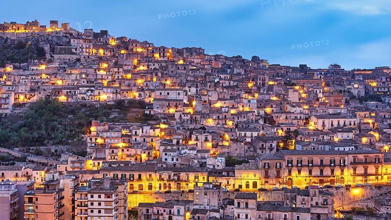 Modica, evening view of a mountainous urban landscape with illuminated houses, Baroque towns of Sicily, Baroque corner of Sicily, late Baroque towns of Val di Noto, UNESCO World Heritage Site, Sicily, Italy
