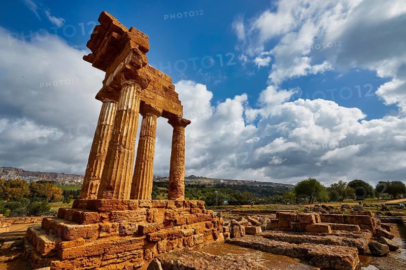 Temple of Dioscuren, ancient temple ruins on a hill under cloudy sky, Valley of the Temples, Valle dei Templi, Archaeological Site, UNESCO World Heritage Site, Agrigento, Sicily, Italy
