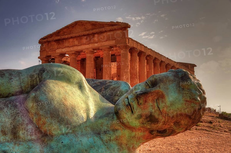 Bronze statue of fallen Icarus, Temple of Concordia, bronze statue in front of an ancient temple in an archaeological site, Valley of the Temples, Valle dei Templi, Archeological Site, UNESCO World Heritage Site, Agrigento, Sicily, Italy