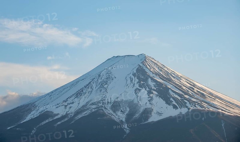 Snow-covered summit of Mount Fuji volcano in spring, in evening light, Arakurayama Sengen Park, Japan