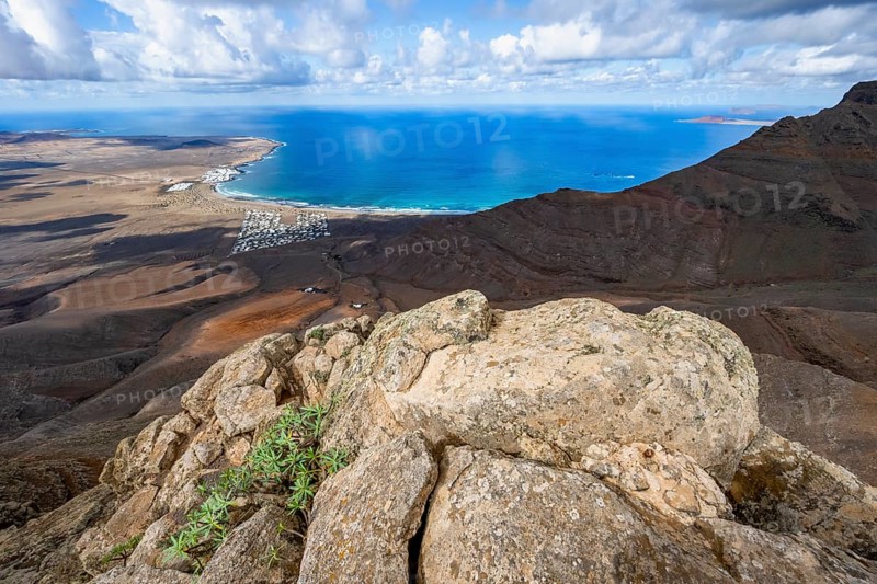 View from the Risco de Famara cliffs to the coast and the sea with the Famara beach, Playa de Famara, Lanzarote, Canary Islands, Spain