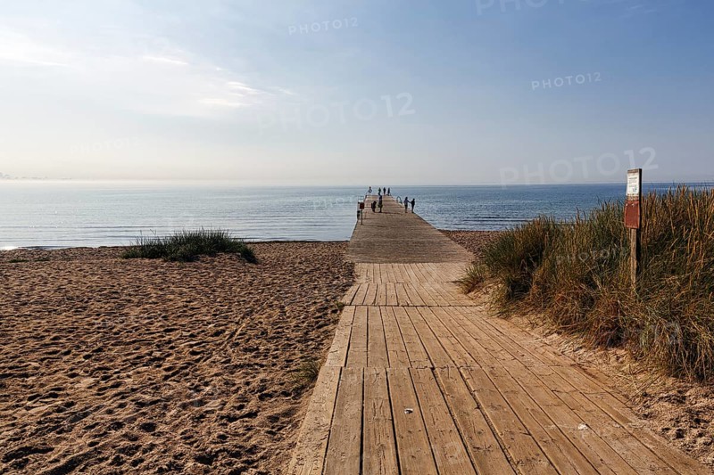 Wooden walkway on the beach, bathers on the horizon, summer in Ystad, Baltic Sea, Sweden