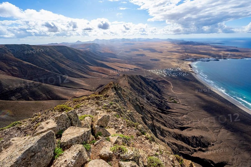 Castillejo viewpoint, view from the Risco de Famara cliffs to the coast and the sea with the Famara beach, Playa de Famara, Lanzarote, Canary Islands, Spain