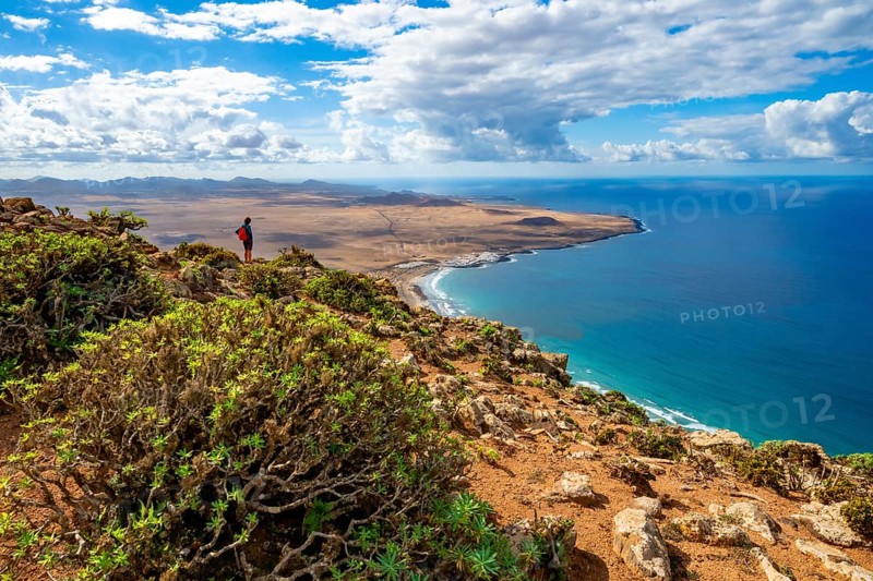 View from the Castillejo viewpoint from the Risco de Famara cliffs to the coast and the sea with the Famara beach, Playa de Famara, Lanzarote, Canary Islands, Spain