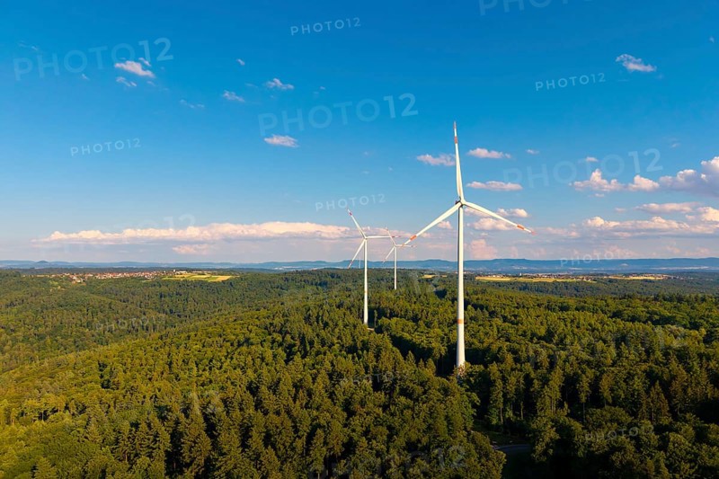 Green forests with several wind power plants under vivid blue sky with clouds, near Schorndorf, Rems-Murr-Kreis, Baden-Württemberg, Germany