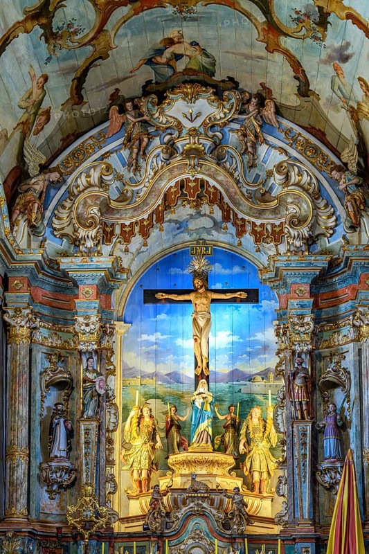 An old Baroque altar with a crucified Jesus, full of colors and images, in the Sanctuary of Bom Jesus de Matosinhos in Congonhas, Minas Gerais