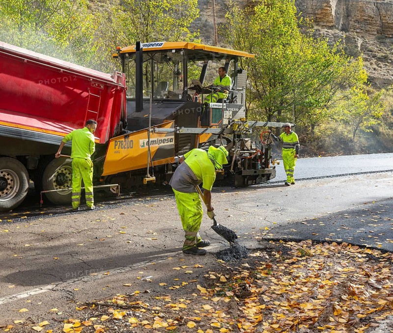 Asphalt road construction team of workers resurfacing tarmac in rural area, near Albarracin, Teruel province, Aragon, Spain
