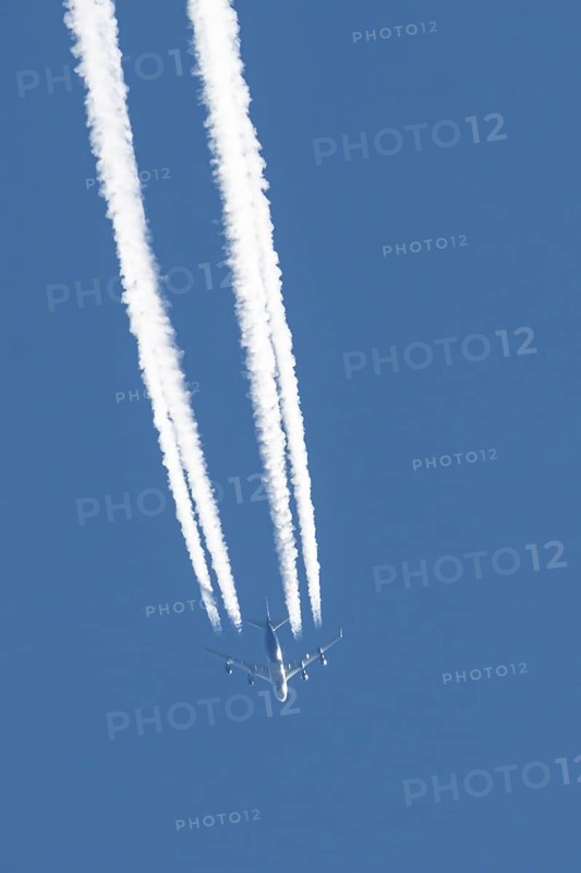 Boeing 747 jumbo jet cargo aircraft of Atlas air airlines flying in a blue sky with contrails or vapour trails behind, England, United Kingdom