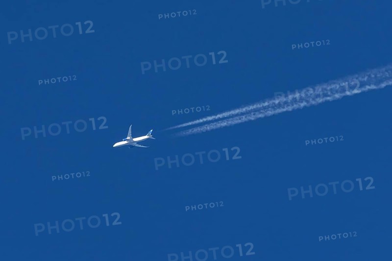 Boeing jet passenger aircraft of United airways airlines flying in a blue sky with contrails or vapour trails behind, England, United Kingdom
