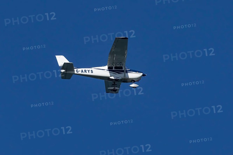 Cessna 172C Skyhawk light aircraft flying in a blue sky, England, United Kingdom