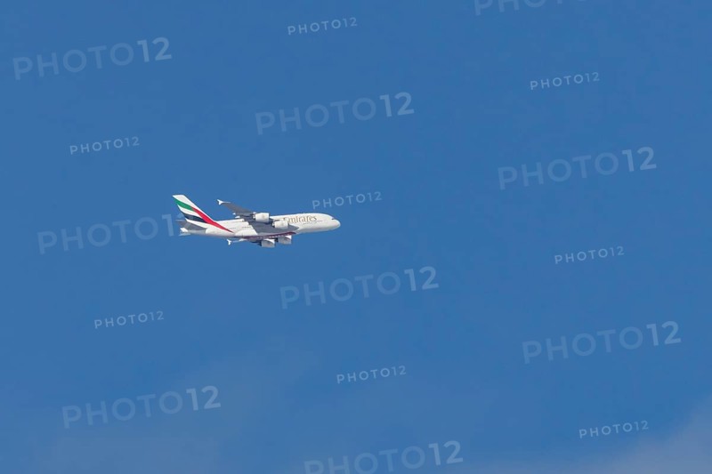 Airbus A380 jet passenger aircraft of Emirates airlines flying in a blue sky, England, United Kingdom
