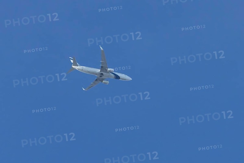 Boeing 737 jet passenger aircraft of El Al Israel airlines flying in a blue sky, England, United Kingdom