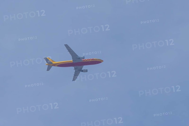 Boeing 767 jet cargo aircraft of DHL airlines flying in a blue sky, England, United Kingdom