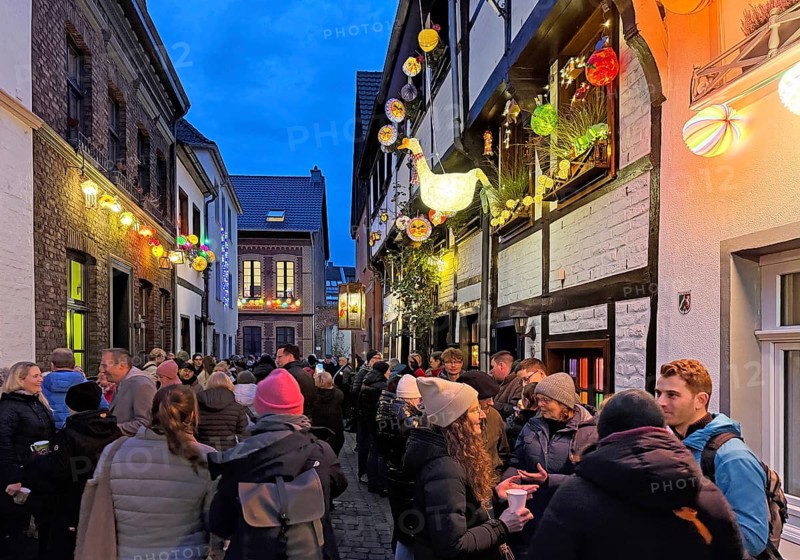 People on the Alte Schulstraße decorated for the Martin train in the evening, Old Town, Kempen, Lower Rhine, North Rhine-Westphalia, Germany
