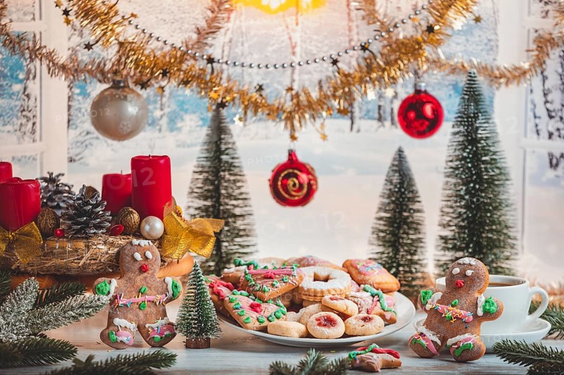 Christmas table with cookies, balls and decoration in front of snowy landscape
