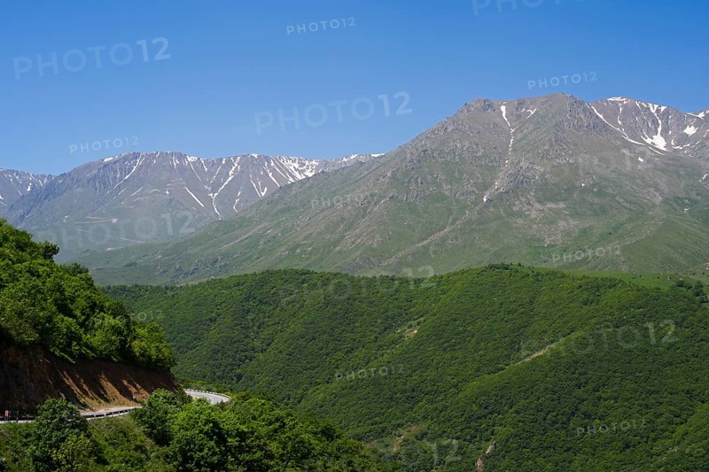 Green wooded hills and majestic mountains under clear blue sky, landscape on M2 near Meghri Pass, Tashtun Pass, Syunik Province, Syunik, Armenia