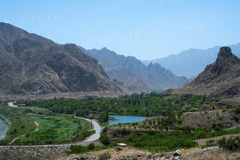 A picturesque valley with a river, surrounded by high mountains and lots of greenery, view of Iran, Aras River near Meghri, Syunik Province, Armenia