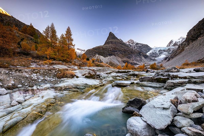 Mountain stream with autumnal larches and mountain views, Mont Mine, Ferpecle glacier, Val d'Herens, Canton of Valais, Switzerland