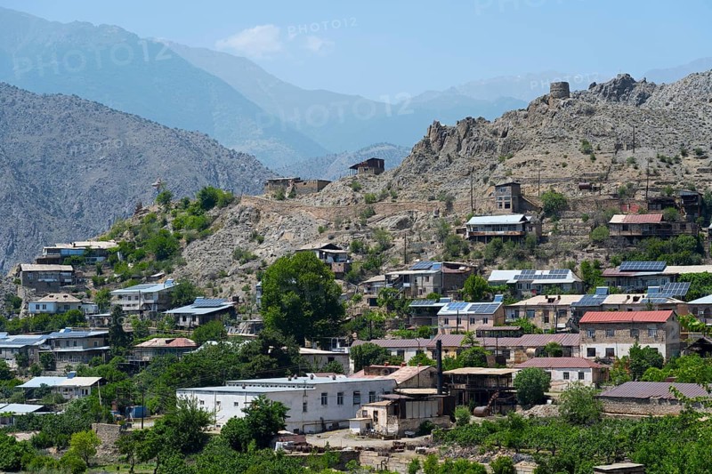 Hilly landscape with a village using solar panels, surrounded by rocky mountains in sunny weather, Meghri, Syunik province, Syunik, not far from the border with Iran, Armenia