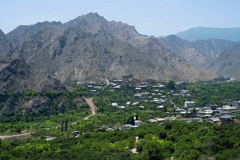 Mountain village with lush vegetation, surrounded by imposing mountains and clear blue sky, Meghri, Syunik province, Syunik, not far from the border with Iran, Armenia