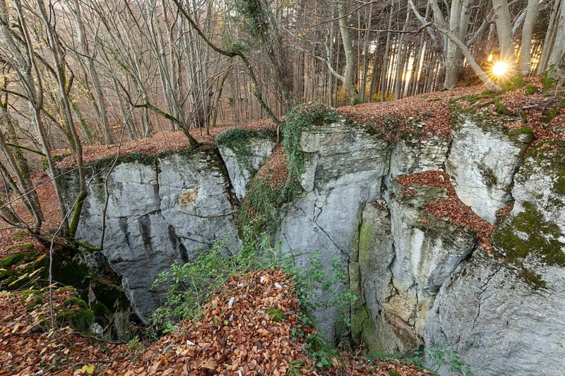 Low sun illuminates the rocks and caves of hell holes in the autumnal landscape of the Swabian Jura near Dettingen an der Erms Baden-Württemberg Germany