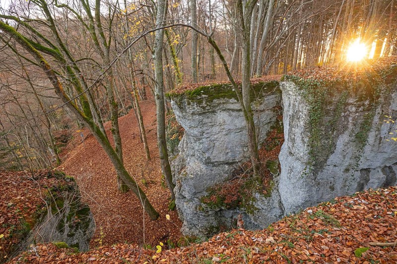 Low sun illuminates the rocks and caves of hell holes in the autumnal landscape of Dettingen an der Erms Baden-Württemberg Germany
