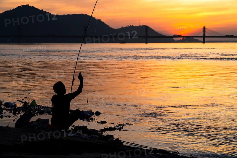 A person fishing in the river Brahmaputra during sunset, on November 4, 2025 in Guwahati, India