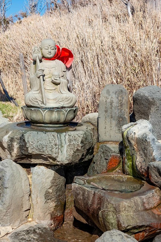 Warm spring water and Buddha statue, Owakudani geothermal area at Komagatake volcano, Hakone, Japan