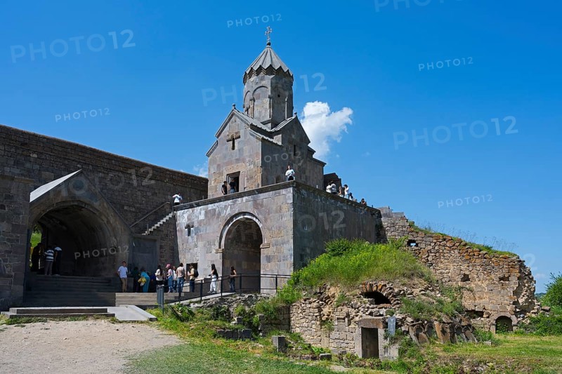 Historic stone church with ruins and grassy areas under clear blue sky, Tatev monastery, Armenian Apostolic monastery, Syunik province, Syunik, Caucasus, Armenia