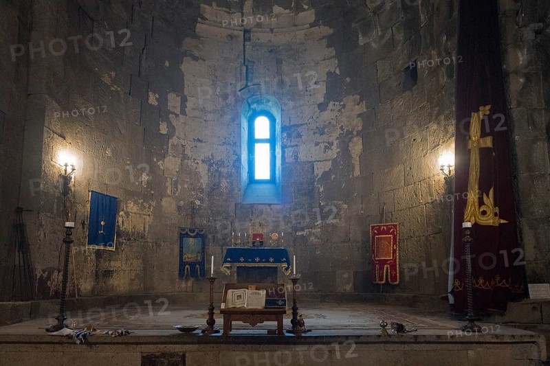 Illuminated church interior with altar, window and candles, filled with sacred atmosphere and decorations, Tatev monastery, Armenian Apostolic monastery, Syunik province, Caucasus, Armenia