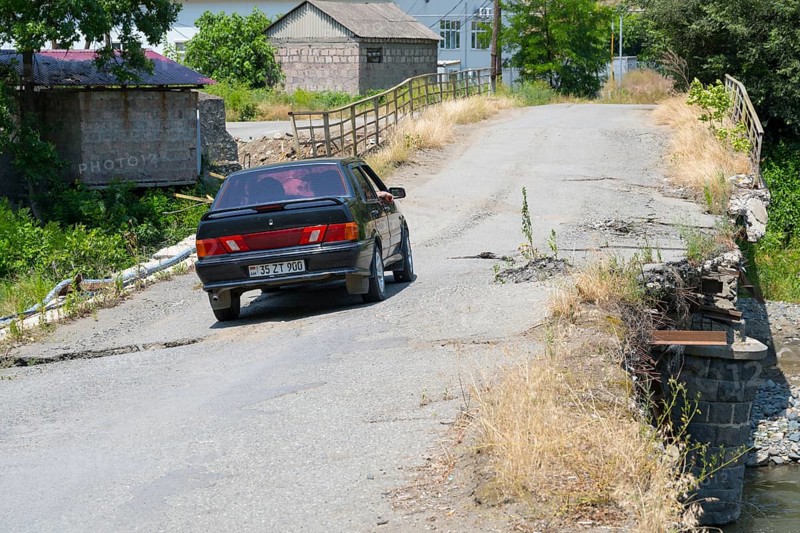 A black car crosses a dilapidated bridge in rural area, Lada Samara drives on bridge over the Debed River, Ayrum, Tavush province, Tavush, Armenia