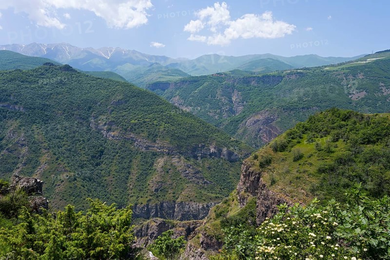 Green mountains under clear sky with white clouds, idyllic and peaceful atmosphere, view from the Halidzor observation deck towards the monastery, Tatev, Syunik province, Syunik, Armenia