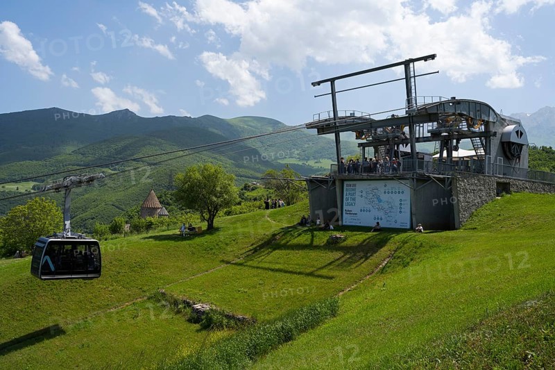 Cable car complex on green field against a background of mountains and cloudy sky, Tatev cable car, Wings of Tatev, Tatev wing, cable car station in Tatev with Tatev monastery, Syunik province, Syunik, Caucasus, Armenia