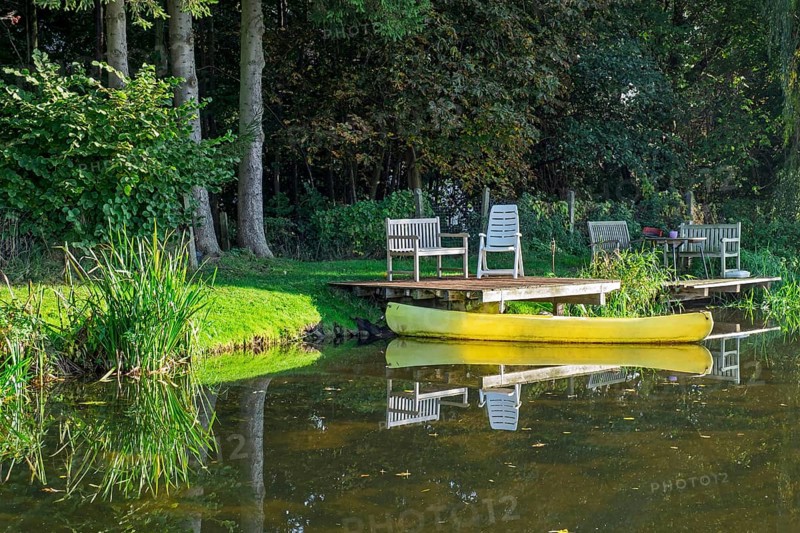 A jetty with benches and a yellow canoe on a quiet river, Dinkel River, Heek-Nienborg, Münsterland, North Rhine-Westphalia, Germany
