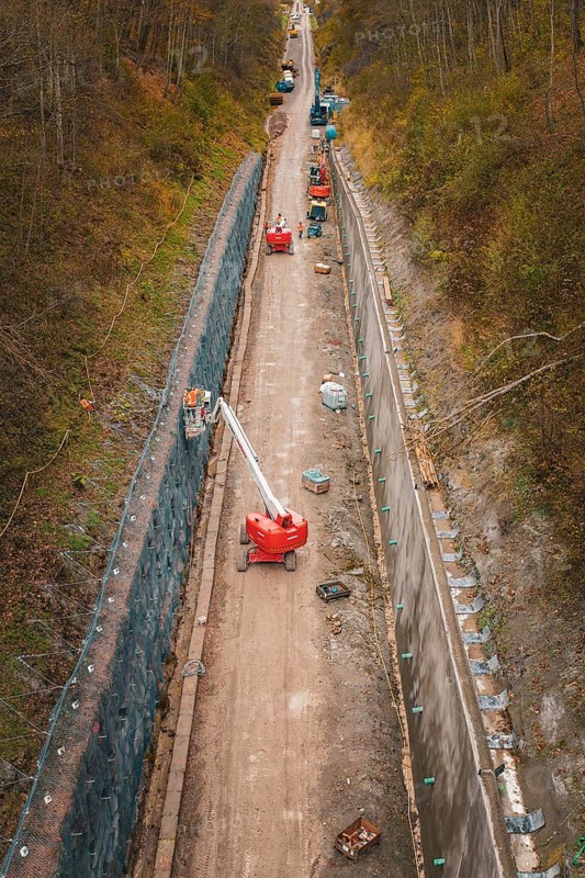 Construction work on a path in a wooded area with machines and a lift, construction of the Hermann Hesse Railway, Im Hau, Calw, Germany