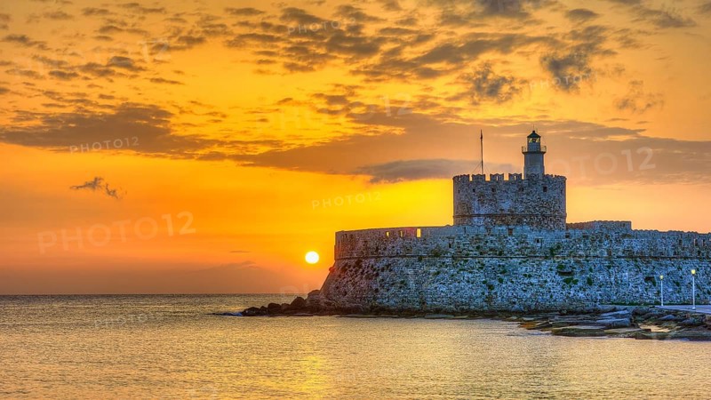 Agios Nikolaos fortress, glowing sunrise behind a castle by the sea, conveys peace, UNESCO World Heritage Site, Old Town of Rhodes Town, Rhodes, Dodecanese, Greece