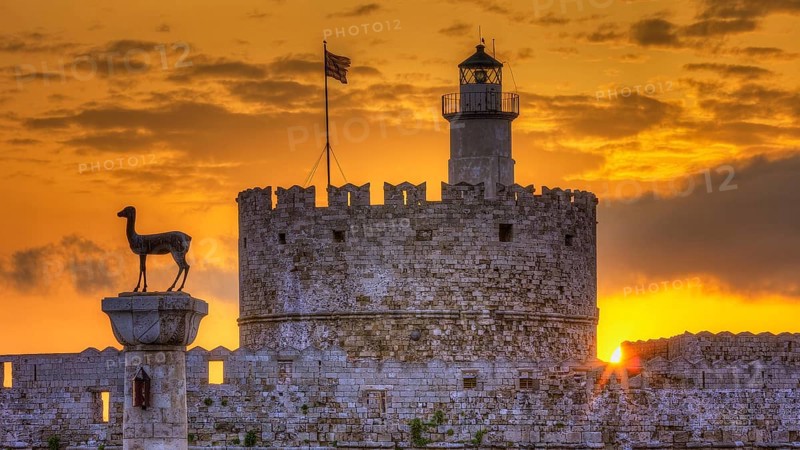 Agios Nikolaos fortress, historic castle with statue in front of a warm sunrise sky, UNESCO World Heritage Site, Old Town of Rhodes Town, Rhodes, Dodecanese, Greece