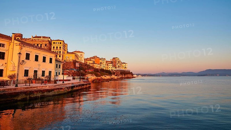 Picturesque coastal town at sunrise with reflection in water, UNESCO World Heritage Site, Old Town of Corfu, Corfu, Kerkyra, Ionian Islands, Greece