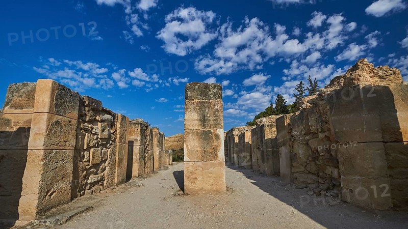 Old ruins with high stone walls under blue sky with scattered clouds, UNESCO World Heritage Site, Minoan Palace of Festos, Crete, Greece